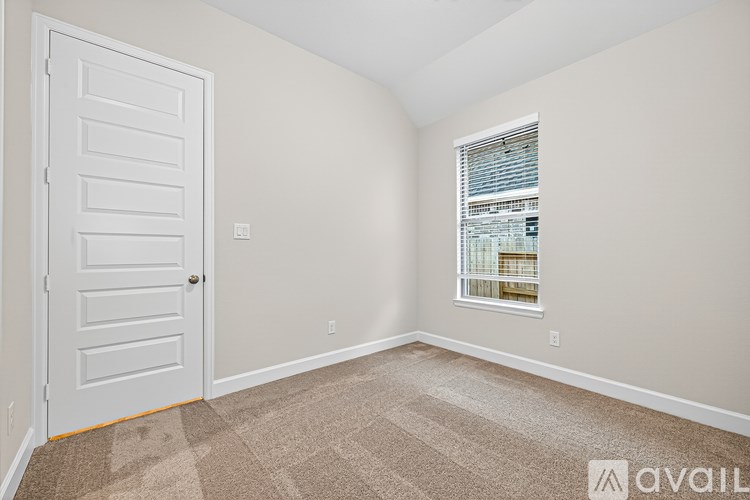 A room with a door and a window with blinds.