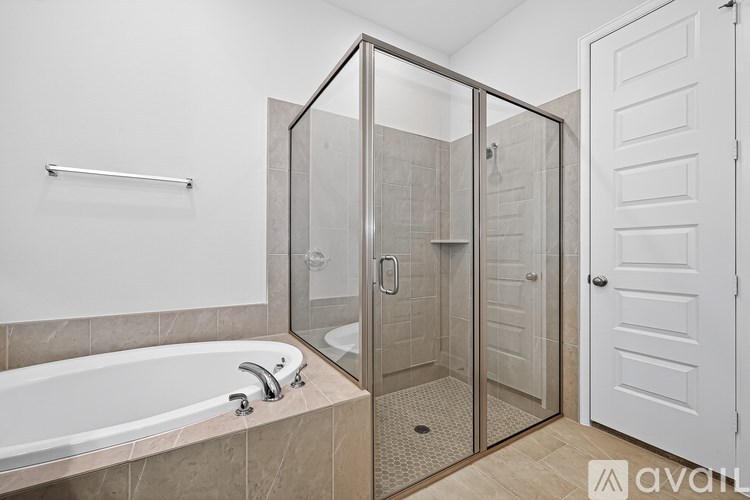 A bathroom with a tub, shower, and a white door.