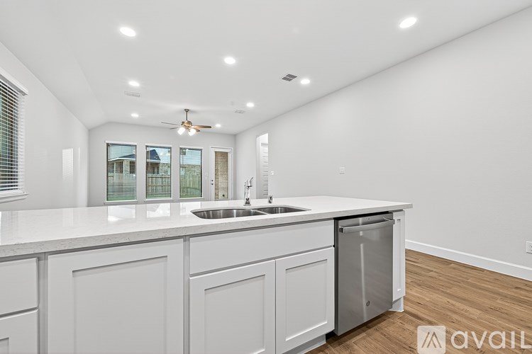 A modern kitchen with white cabinets and a large island.