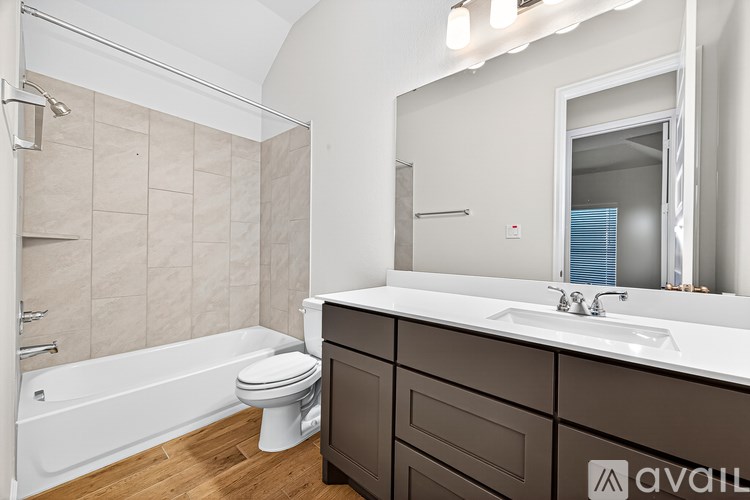 A bathroom with a white tub, sink, and toilet.