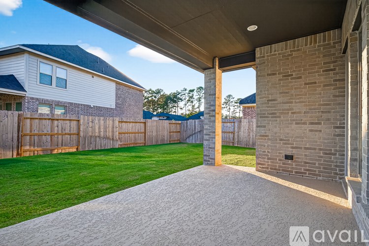 A house with a covered patio and a brick pillar.