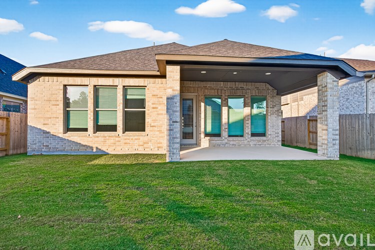 A house with a brown roof and a green lawn in front.
