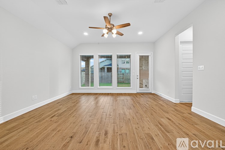 A room with wooden flooring and a ceiling fan.