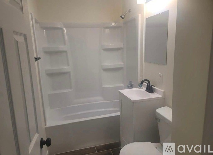A white bathroom with a walk-in shower and a toilet.