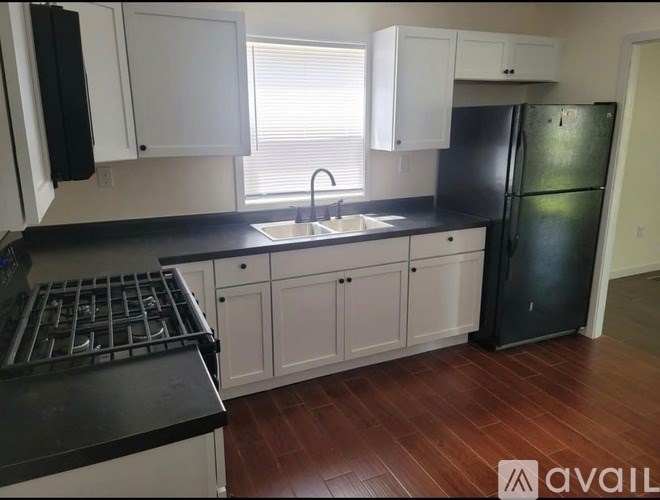 A kitchen with black countertops and white cabinets.