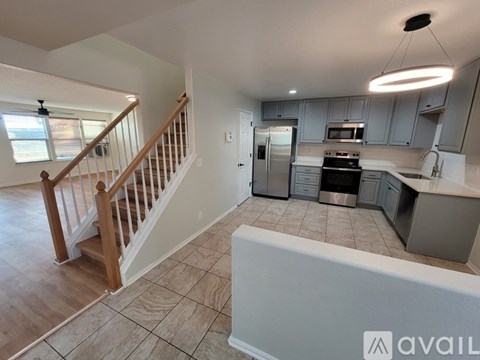 A kitchen with a refrigerator, oven, and microwave.