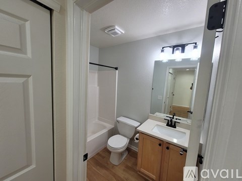 A bathroom with a toilet, sink, and mirror.
