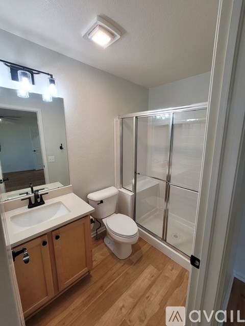 A bathroom with a toilet, sink, and shower.