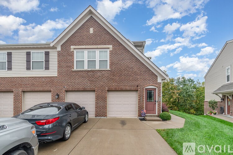 A house with a brick facade and a car parked in front.