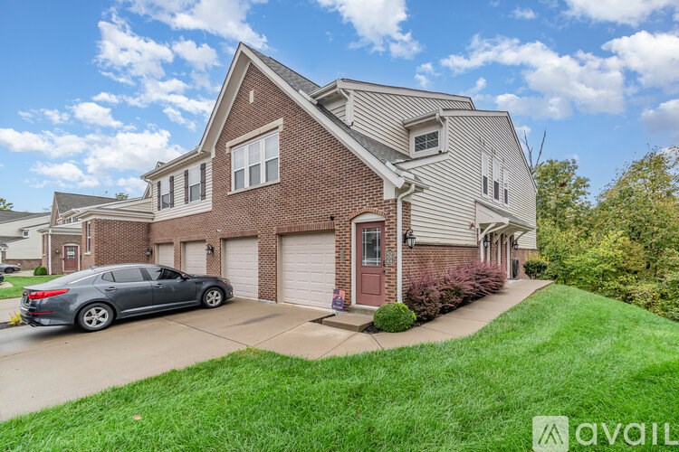 A house with a grey car parked in front.