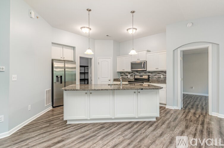 A kitchen with white cabinets and a granite countertop.