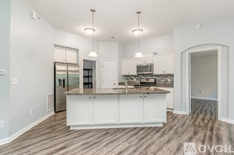 A kitchen with white cabinets and a granite countertop.