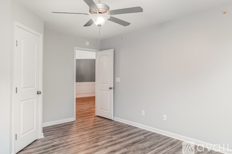 A room with a ceiling fan and wooden flooring.
