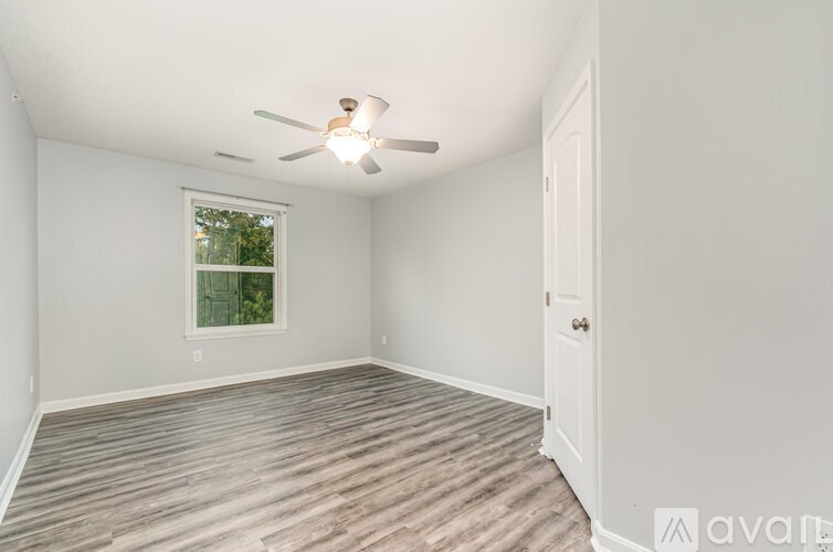 A room with a ceiling fan and a window.