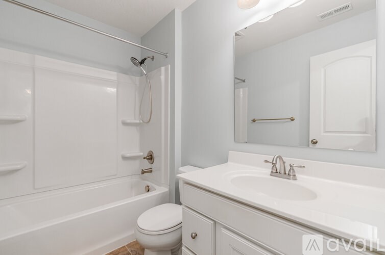 A white bathroom with a toilet, sink, and bathtub.