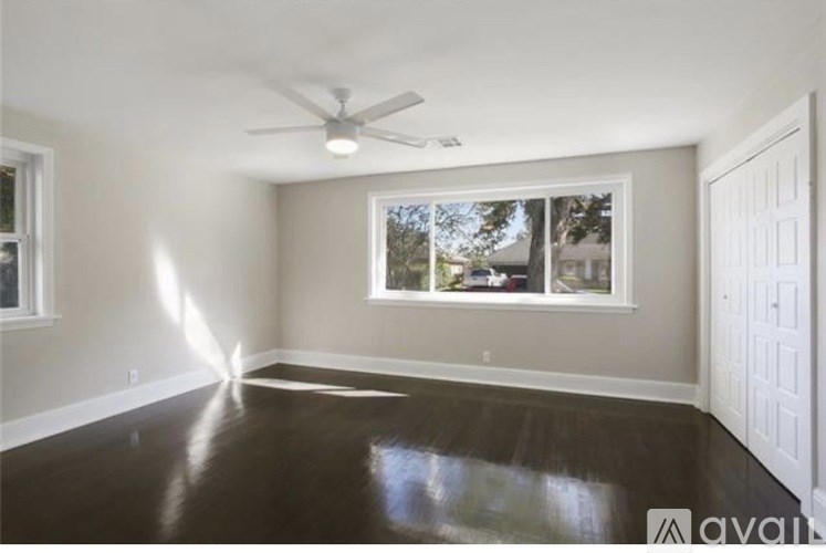 A room with a ceiling fan and a window.