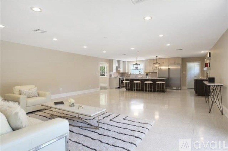 A spacious living room with a white couch and a black and white striped rug.