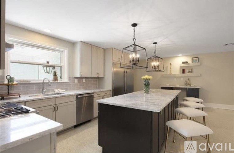 A kitchen with a marble island and stainless steel appliances.