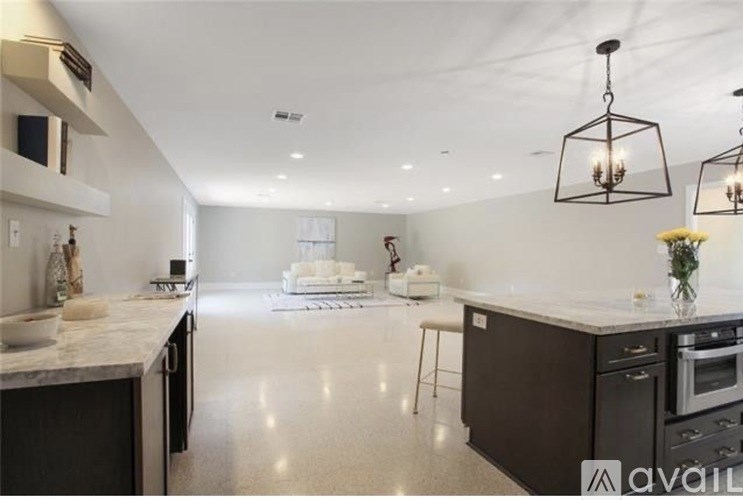 A modern kitchen with dark brown cabinets and a marble countertop.