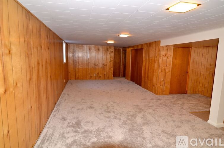 A room with wooden walls and carpeted floor.