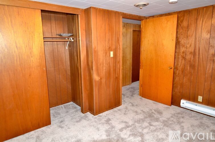 A room with wooden walls and doors, and a carpeted floor.