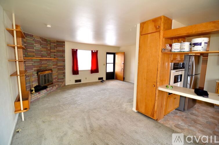 A living room with a fireplace and a wooden bookshelf.