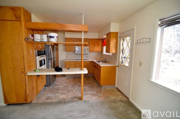 A kitchen with wooden cabinets and a bench.