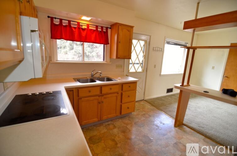 A kitchen with wooden cabinets and a black stove top.
