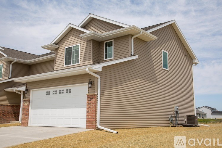 A house with a garage door and a brown siding.