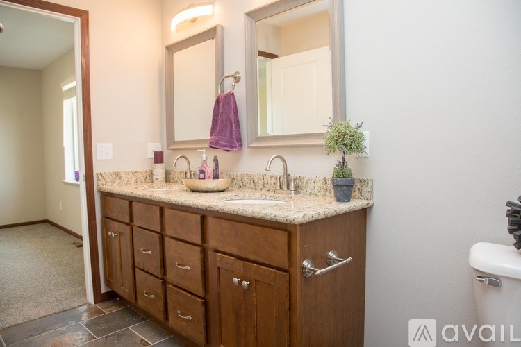 A bathroom with a vanity, sink, and mirror.