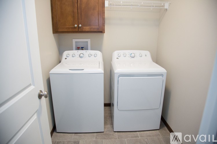Two white front loading washing machines in a small laundry room.