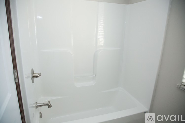 A white bathroom with a tub and a door.