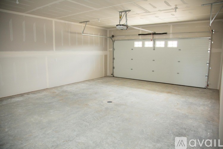 A large empty garage with a white door and a concrete floor.