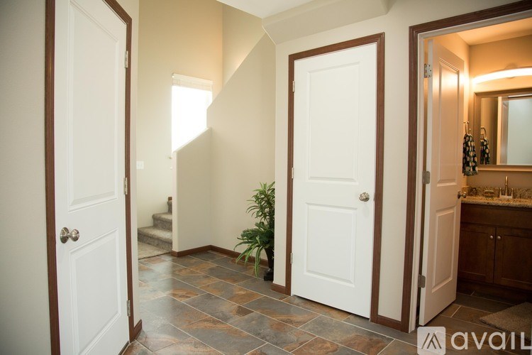 A bathroom with a tiled floor and a mirror above a sink.