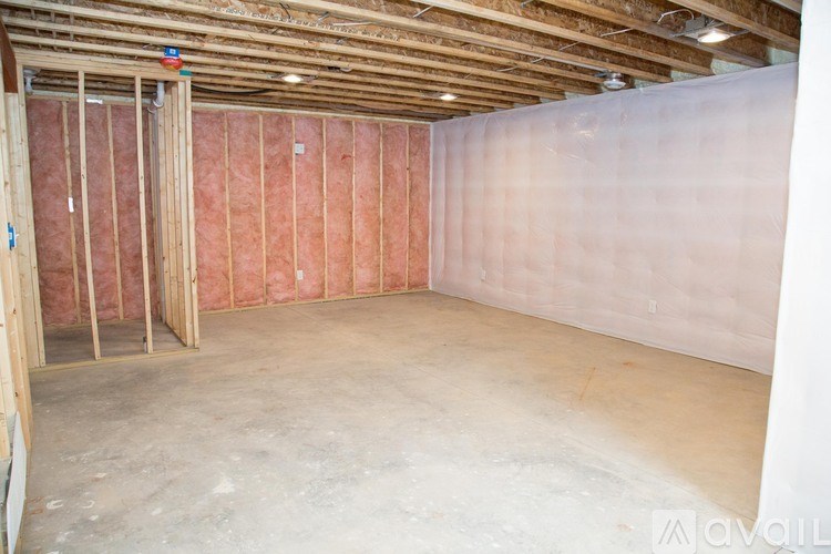A room under construction with wooden framing and drywall.