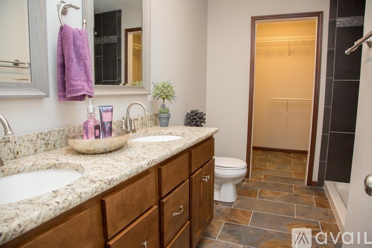 A bathroom with a marble countertop and a toilet in the corner.