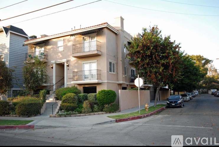 A two-story beige apartment building with a balcony on the second floor.