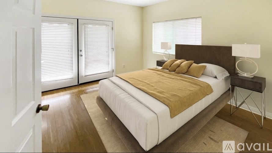 A bedroom with a bed, nightstand, and window with blinds.