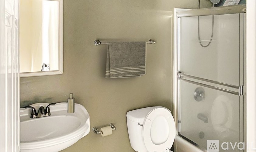 A bathroom with a toilet, sink, and shower.