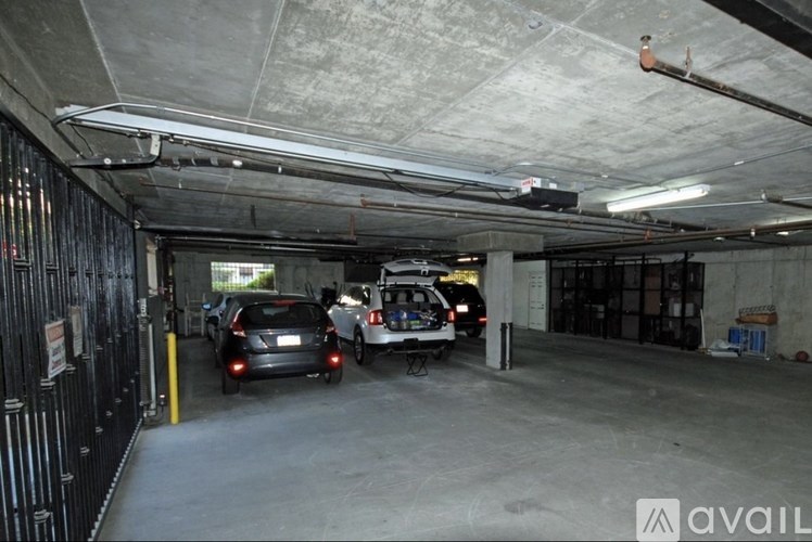 A parking garage with a few cars parked in it.