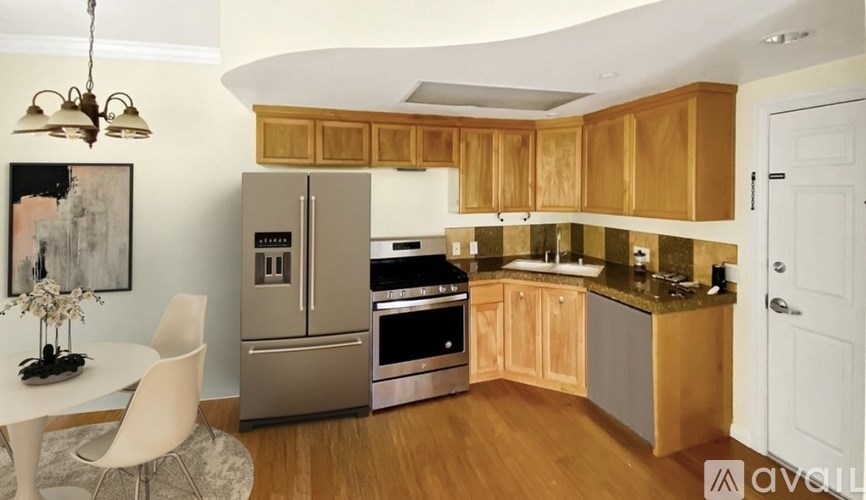 A kitchen with wooden cabinets and a white table.