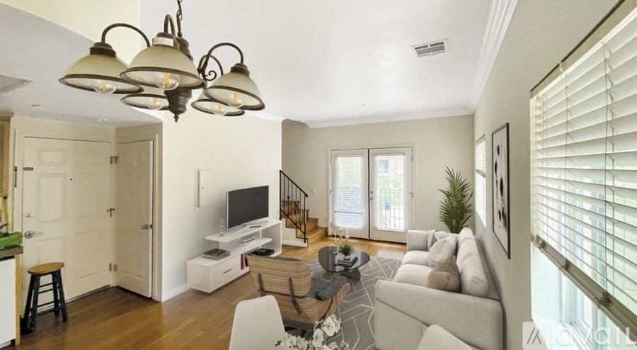 A well-lit living room with a television, couch, and a bar area.