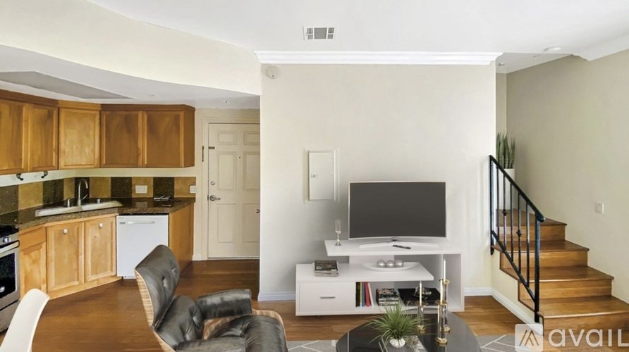 A living room with a television and a staircase.