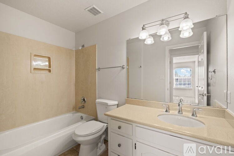 A bathroom with a white tub, sink, and toilet.