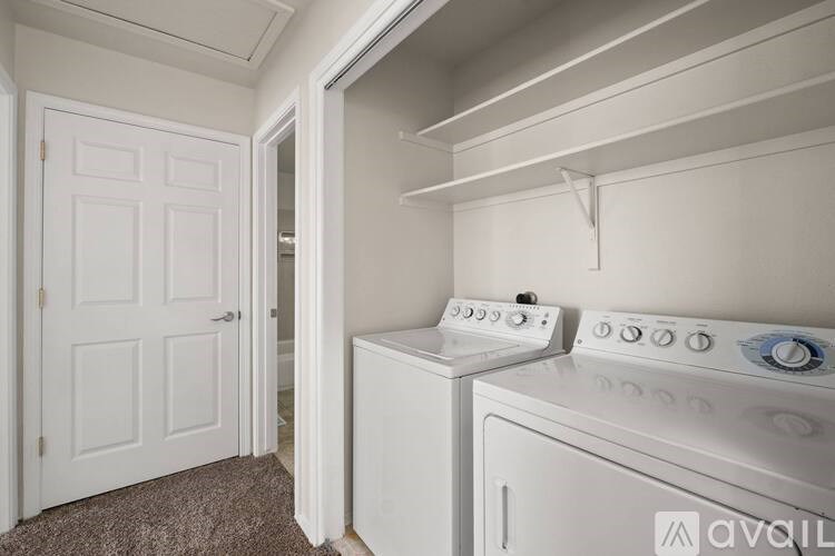 A white washing machine sits in a small laundry room.