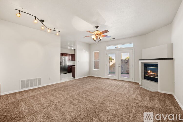 A spacious living room with a fireplace and a ceiling fan.