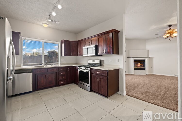 A kitchen with brown cabinets and a stainless steel refrigerator.