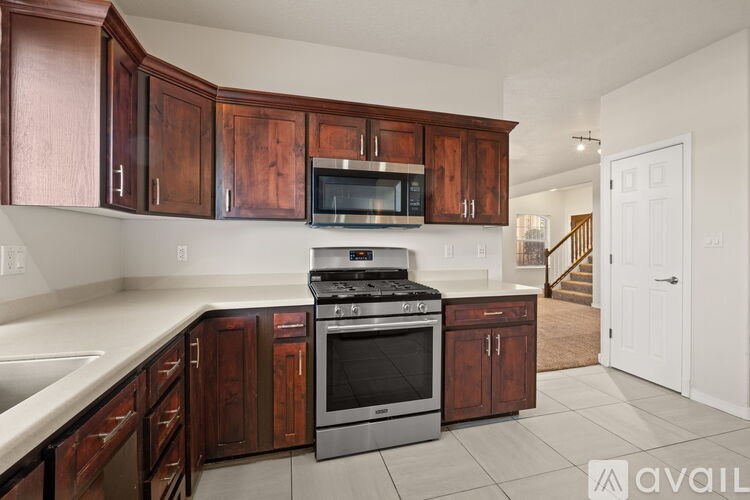 A kitchen with wooden cabinets and a stainless steel oven.