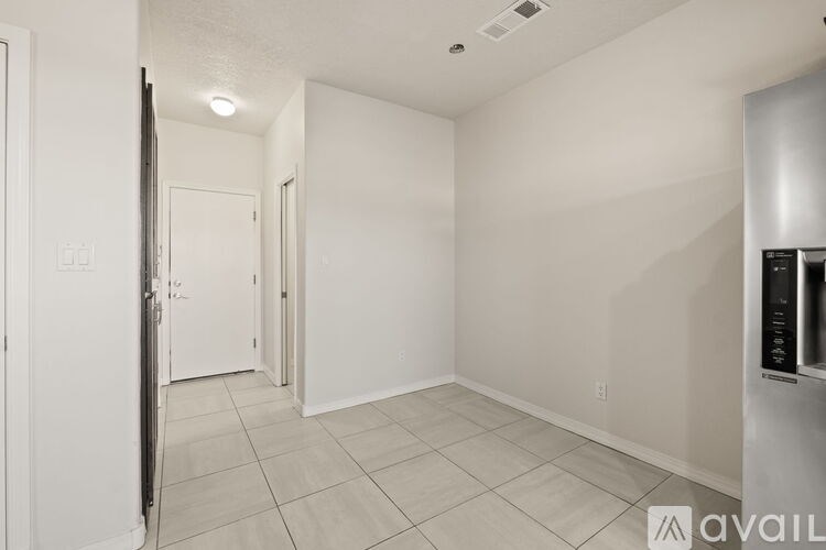 A white room with a door and a wall-mounted air conditioner unit.