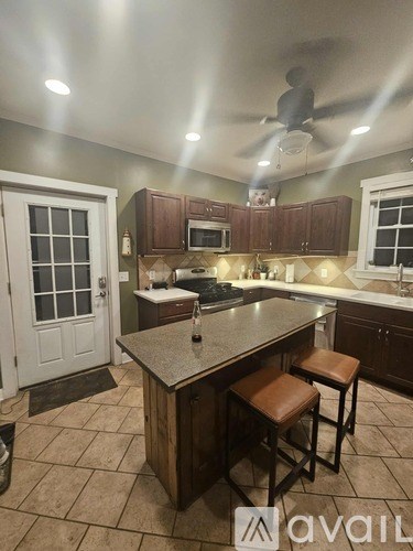 A kitchen with a bar stool and a counter.